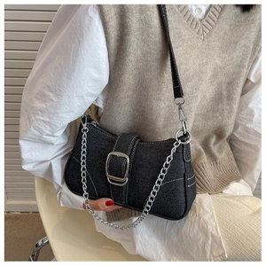 Dettaglio della borsa a spalla in denim nero con catena argento e grande fibbia quadrata