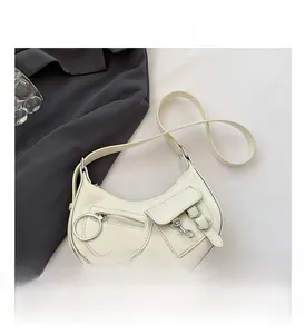 Détail du sac hobo crème avec boucles argentées et finition en cuir brillant