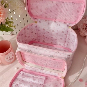 Detail of pink cartoon cosmetic bag featuring multi-layer storage and mesh pocket