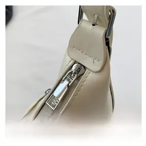 Vue détaillée du zip en métal argenté de qualité sur le sac à bandoulière en cuir couleur crème