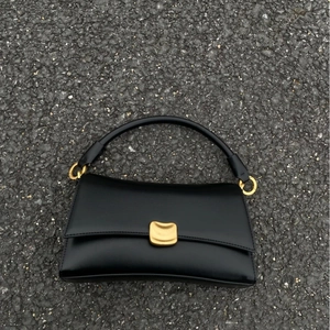 Elegante borsa sottobraccio in pelle nera con fibbia dorata e raffinati anelli in metallo
