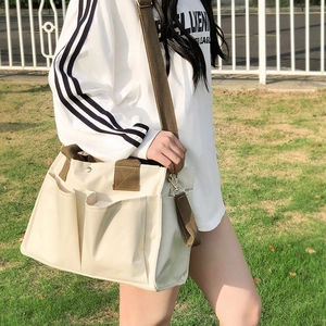 Multi-pocket canvas mommy bag with brown nylon straps in an outdoor lifestyle scene