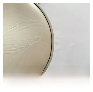 Gros plan sur le cuir crème avec motif de veines de feuilles gaufrées et coutures soignées