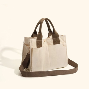 Minimalist beige canvas mommy tote bag with brown straps and multiple storage pockets