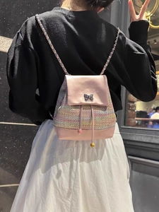 Detail of pink tweed backpack with a metallic butterfly clasp and leather chain strap