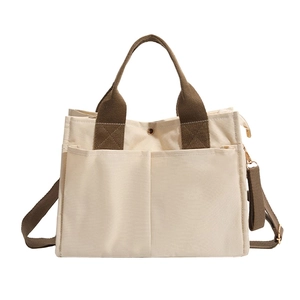Minimalist canvas tote bag with multi-pocket design and adjustable brown straps