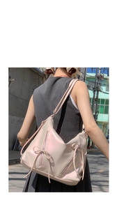 Detail of pearl beige hobo bag showing bow-tie zippers and shimmering leather texture