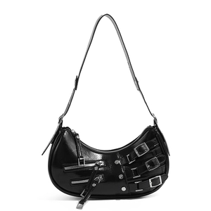 Detail of black glossy crescent bag featuring silver buckles and functional zippers