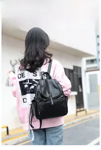 Dettaglio dello zaino nero in PU con bordo intrecciato e cerniera alla moda con nappe