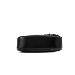 Detail view of glossy black leather bag showing the sturdy bottom and silver metal buckle