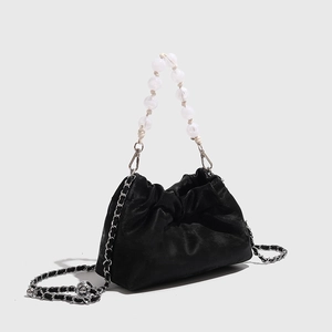 Detail der schwarzen Cloud-Tasche mit Perlengriff und silberner Metallkette für Damen