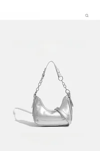 Detailed view of silver metallic crescent hobo bag with chain strap and branding