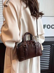 Detail of dark brown vintage Boston bag showing textured leather and silver hardware