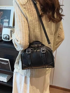 Retro black Boston handbag with silver buckles and adjustable strap in lifestyle setting