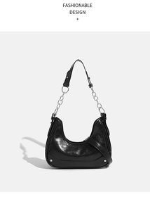 Detail of black crescent hobo bag featuring glossy leather texture and silver chain strap