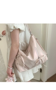 Detailed side view of the cream pink tote bag with bow drawstring and vertical zipper
