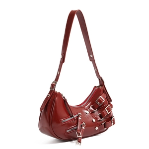 Detail of dark red patent leather crescent bag with punk buckles and metal zippers