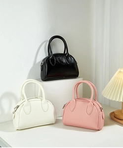 Chic mini Boston bags in black, beige, and pink leather with metallic zipper detail