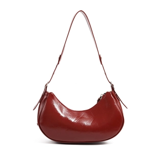 Detail view of the sleek dark red glossy crescent bag with polished metal zipper finish