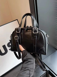 Detail of black Boston bag showing natural lychee texture and silver metal buckles