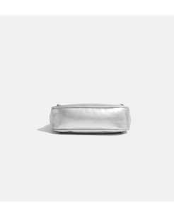 Detail of silver metallic shoulder bag bottom with four protective metal studs and neat stitching