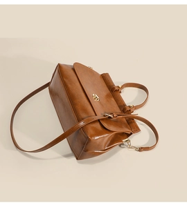 Dettaglio della borsa in pelle marrone vintage con chiusura girevole in metallo dorato