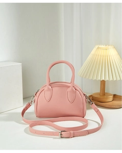 Detail of pink Boston bag with double handles and adjustable silver buckle shoulder strap
