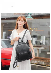 Fashionable black leather backpack with panda charm on model in urban street setting