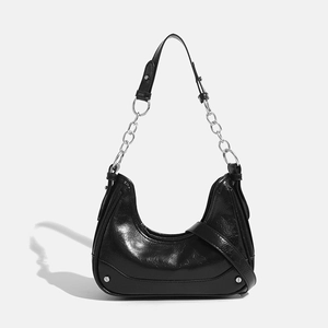 Glossy black crescent shoulder bag with silver chain strap on white background