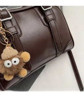 Detailed macro view of dark brown lychee-patterned leather bag with silver metal hardware