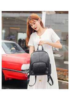 Outdoor shot of black soft leather backpack with zipper pocket and metal hardware