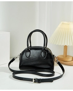Detail of black wax leather Boston bag with silver hardware and adjustable strap