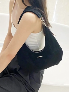 Detailed view of the black crescent hobo bag worn on the shoulder with metal zipper