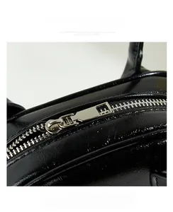 Detail of silver metal zipper and black lychee grain leather on the Boston bag