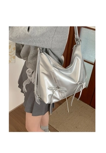Detail of silver metallic backpack with bow decorations and vertical zipper accents