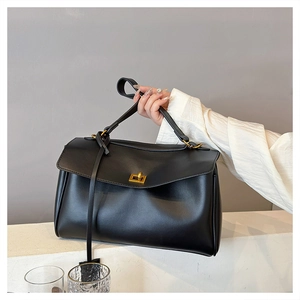 Detail of black tote bag with smooth texture and elegant golden twist lock closure