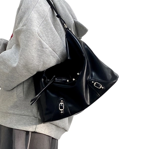 Detail of black large hobo shoulder bag featuring silver metal rivets and matte leather finish