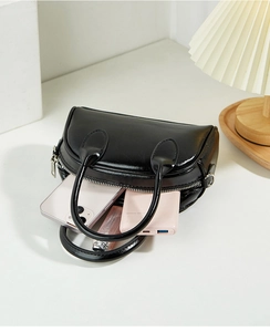 Detail view of black Boston bag interior showing smartphone and lipstick storage