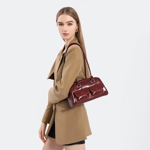 Deep red oil-wax leather bowling bag with side pockets shown on a model for commute style