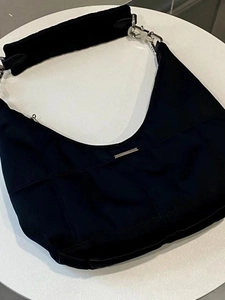 Detailed top view of a black crescent shoulder bag with silver metallic hardware