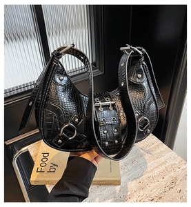 Black croc embossed leather motorcycle shoulder bag, detailed view of rivets and double buckles.