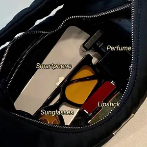 Black crescent shoulder bag showing spacious interior with phone, perfume and lipstick