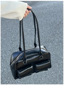 Detail view of black oil wax leather bowling bag with functional double front pockets