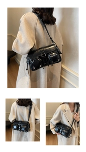 Detail of black glossy hobo bag featuring silver eyelets and multi-pocket utility design