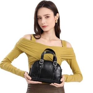 Classic black Boston bag with glossy leather texture and silver buckle shown on model