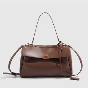 Détail d'un sac cabas marron foncé élégant avec fermoir rotatif rectangulaire doré