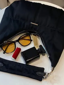Quilted black nylon crescent bag with silver zipper and stylish lifestyle accessories