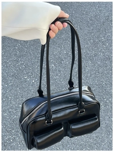 Detail view of black oiled leather bag showing silver zipper and twin flap pockets