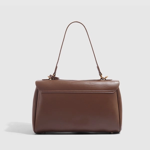 Détail du sac fourre-tout en cuir marron foncé avec rabat élégant et ferrures métalliques