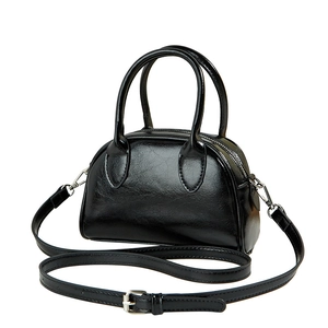 Minimalist black glossy leather Boston handbag with detachable strap on white background